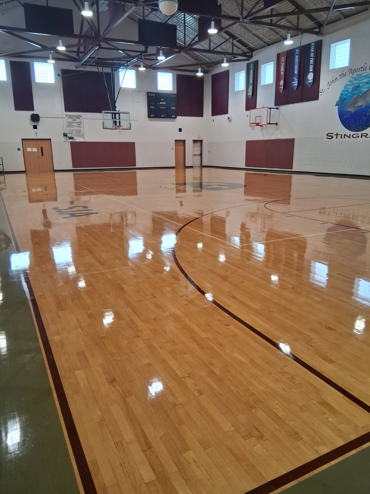 A gymnasium floor stripped, sealed and refinished to a deep, even shine